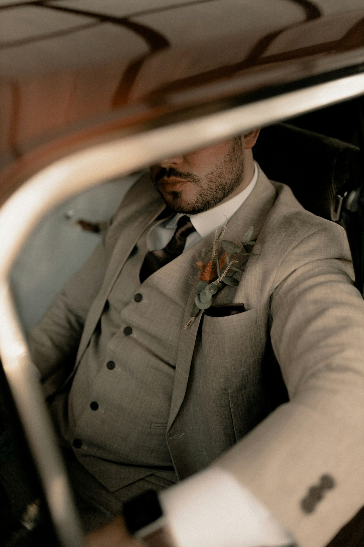 A man in a suit sitting in a car